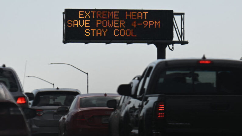 Vehículos pasan junto a una señal en la autopista 110 que advierte del calor extremo e insta a la conservación de la energía durante una ola de calor en el centro de Los Ángeles, California, el 2 de septiembre de 2022. (Patrick T. Fallon/AFP vía Getty Images)