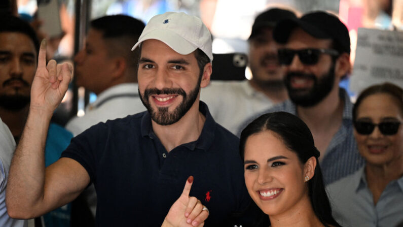El presidente de El Salvador, Nayib Bukele (i), y su esposa, Gabriela Rodríguez, muestran sus dedos entintados tras votar en un colegio electoral durante las elecciones municipales en San Salvador, el 3 de marzo de 2024. (Marvin Recinos/AFP vía Getty Images)