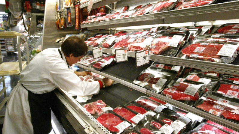 Un carnicero ordena productos cárnicos en una tienda de comestibles el 29 de diciembre de 2003 en Nueva York. (Spencer Platt/Getty Images)