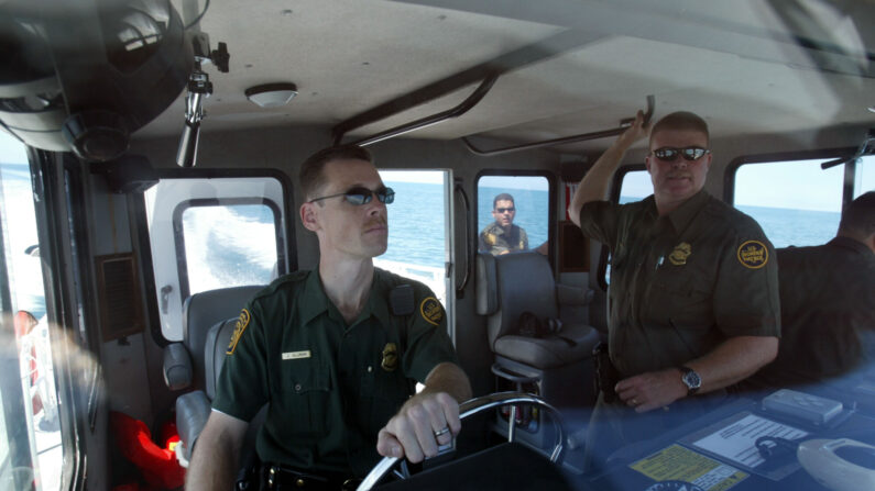Los agentes sénior de la Patrulla Fronteriza de Estados Unidos, John Almond (izquierda) y Russell Ellsworth, patrullan en el bote de la patrulla el 24 de abril de 2004 frente a la costa de Mayagüez, Puerto Rico. (Foto de Joe Raedle/Getty Images)
