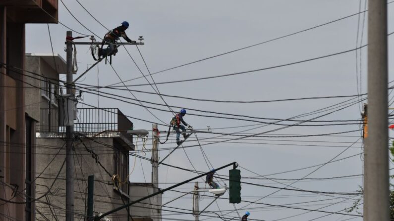 Empleados trabajan en el tendido eléctrico en Ciudad de Guatemala (Guatemala) el 29 de octubre de 2017. (Johan Ordonez/AFP vía Getty Images)