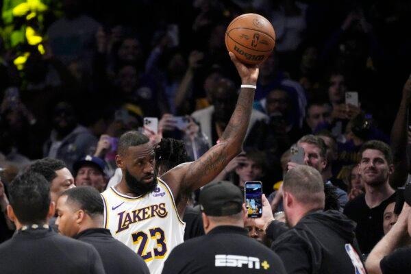 El alero de Los Angeles Lakers, LeBron James, saluda a los fanáticos después de anotar para convertirse en el primer jugador de la NBA en alcanzar los 40.000 puntos en una carrera durante la primera mitad de un partido de baloncesto de la NBA en Los Ángeles el 2 de marzo de 2024. (Mark J. Terrill/AP Photo )