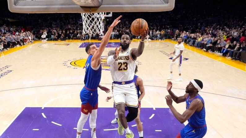 El delantero de Los Angeles Lakers, LeBron James (23), anota mientras el delantero de los Denver Nuggets, Michael Porter Jr., defiende durante la primera mitad de un partido de baloncesto de la NBA en Los Ángeles el 2 de marzo de 2024. (Mark J. Terrill/AP Photo)