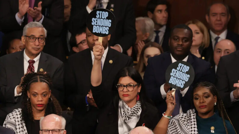 La representante estadounidense Rashida Tlaib (D-MI) (C) y la representante Cori Bush (D-MO) sostienen carteles mientras el presidente Joe Biden pronuncia el discurso sobre el Estado de la Unión en el Capitolio, el 07 de marzo de 2024. (Alex Wong/Getty Images)
