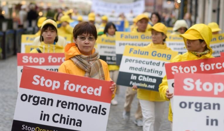 Practicantes de Falun Dafa portan pancartas para crear conciencia sobre la sustracción de órganos en China durante una marcha por el centro de Varsovia, Polonia, el 9 de septiembre de 2022. (Mihut Savu/The Epoch Times)