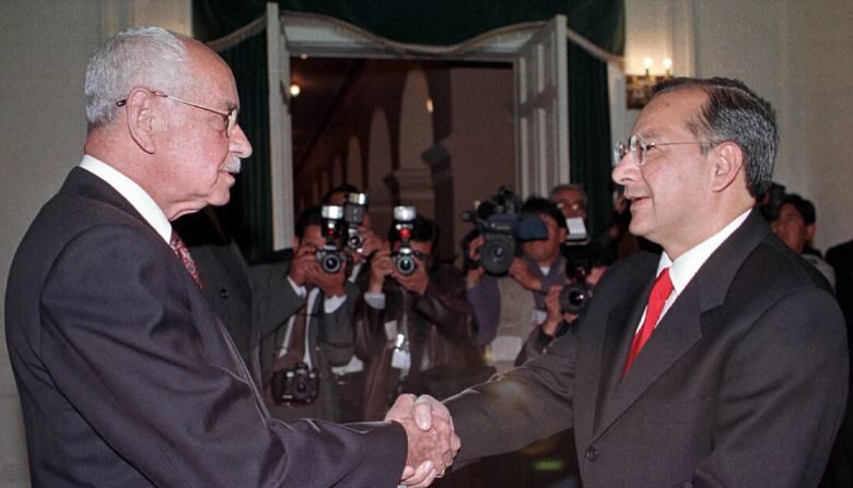 El presidente boliviano Hugo Banzer estrecha la mano de Víctor Manuel Rocha (d), embajador de EE. UU. en Bolivia, durante una ceremonia en el Palacio de Gobierno en La Paz, Bolivia, el 3 de agosto de 2000. (Reuters)