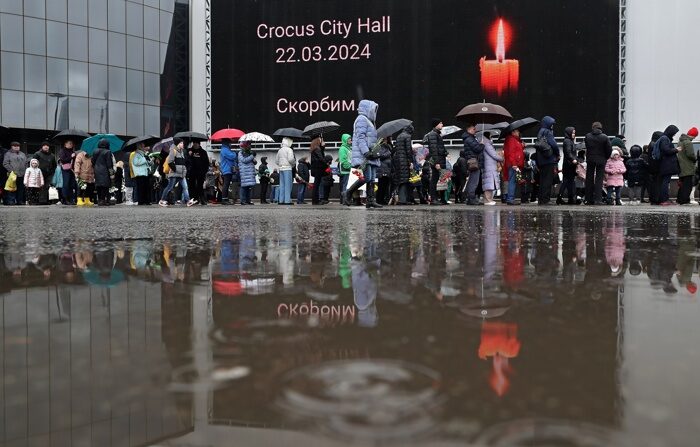 Ciudadanos expresan este domingo sus condolencias ante la sala de conciertos del Crocus City Hall, en la localidad rusa de Krasnogorsk, cerca de Moscú, tras el atentado terrorista perpetrado en ese lugar el pasado viernes. (EFE/EPA/Maxim Shipenkov)