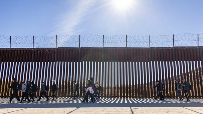 Inmigrantes ilegales que atravesaron una brecha en el muro fronterizo estadounidense esperan a ser procesados por agentes de la Patrulla Fronteriza en Jacumba, California, el 7 de diciembre de 2023. (John Fredricks/The Epoch Times)