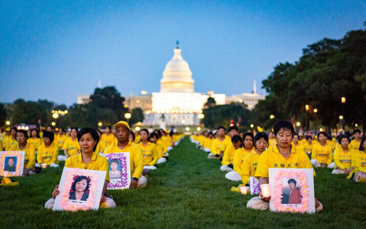 Practicantes de Falun Dafa durante una vigilia con velas en conmemoración a los practicantes de Falun Dafa que fallecieron debido a los 24 años de persecución del Partido Comunista Chino (PCCh), en el National Mall de Washington, el 20 de julio de 2023. (Samira Bouaou/The Epoch Times
