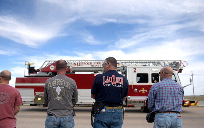 Los socorristas del condado de Lubbock hacen una pausa mientras pasa la procesión del jefe de bomberos de Fritch, Zeb Smith, en Lubbock, Texas, el 5 de marzo de 2024. (Annie Rice/Lubbock Avalanche-Journal vía AP)
