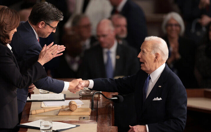 El presidente Joe Biden le da la mano al presidente de la Cámara, Mike Johnson (R-LA), mientras la vicepresidenta Kamala Harris aplaude después de que el presidente pronunció el discurso sobre el estado de la Unión durante una reunión conjunta del Congreso, en el Capitolio de EE.UU., el 7 de marzo de 2024. (Gana McNamee/Getty Images)