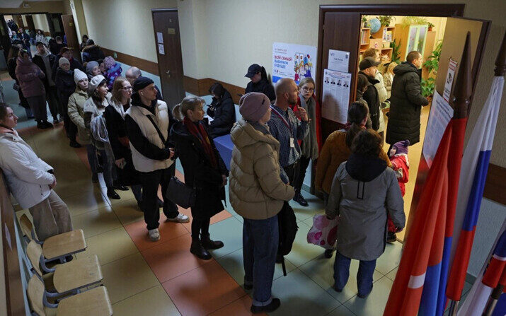 La gente hace fila para ingresar a un colegio electoral alrededor del mediodía del último día de las elecciones presidenciales, en la ciudad de Kudrovo, Rusia, el 17 de marzo de 2024. (Anton Vaganov/Reuters)
