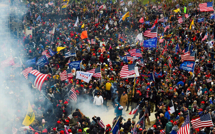 Una nube de gas lacrimógeno atraviesa la multitud de manifestantes en la plaza oeste del Capitolio de EE.UU., el 6 de enero de 2021. (Roberto Schmidt/AFP vía Getty Images)