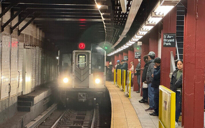 Los usuarios del metro se paran cerca de barreras amarillas en un andén antes de la llegada del tren 7, en Nueva York, el 26 de marzo de 2024. (Cedar Attanasio/Foto AP)