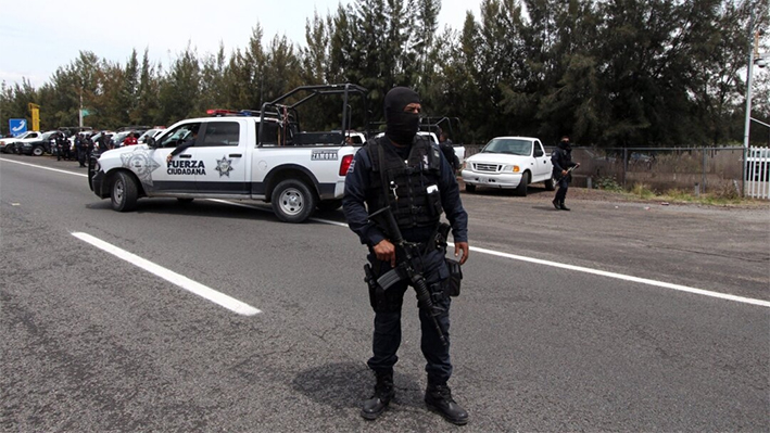 Policías federales montan guardia frente al rancho donde se refugiaron hombres armados durante un intenso tiroteo con la policía, a lo largo de la carretera Jalisco-Michoacán en Vista Hermosa, estado de Michoacán, México, el 22 de mayo de 2015. (Héctor Guerrero/AFP vía Getty Images)
