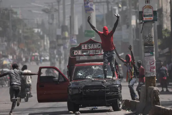 Un hombre con la cara cubierta pide a los manifestantes que se detengan durante una protesta contra el gobierno del primer ministro Ariel Henry y la inseguridad, en Puerto Príncipe, Haití, 1 de marzo de 2024. (Ralph Tedy Erol/Reuters)
