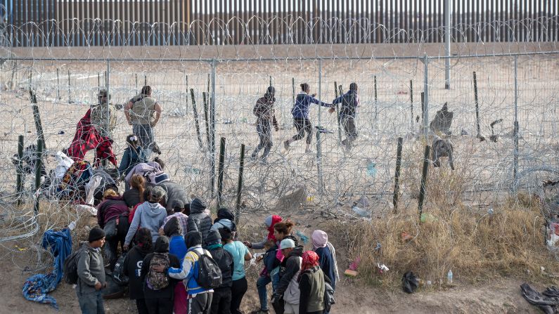 Migrantes violan la valla fronteriza instalada por la Guardia Nacional de Texas en el Río Grande en El Paso, Texas, el jueves 21 de marzo de 2024. (Omar Ornelas/El Paso Times vía AP)