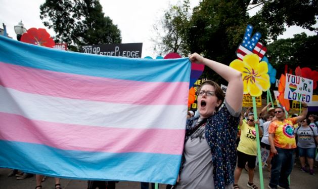 Una activista a favor de la transexualidad sostiene una bandera en un evento en Atlanta, Georgia, el 12 de octubre de 2019. (AP Photo/Robin Rayne, archivo)