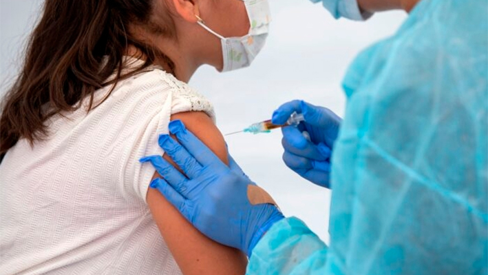 Un trabajador sanitario vacuna a un estudiante durante una clínica comunitaria en Los Ángeles, California, el 12 de agosto de 2020. (Valerie Macon/AFP vía Getty Images)
