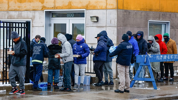 Un grupo de inmigrantes ilegales recibe comida en Chicago, Illinois, el 12 de enero de 2024. (Kamil Krzaczynski/AFP vía Getty Images)
