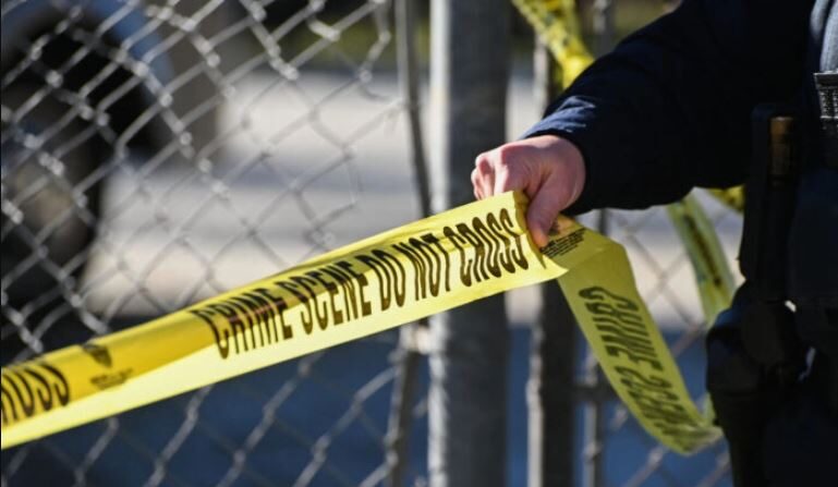 Un agente de la ley coloca cinta policial en la escena de un crimen en Half Moon Bay, California, el 24 de enero de 2023. (Samantha Laurey/AFP vía Getty Images)