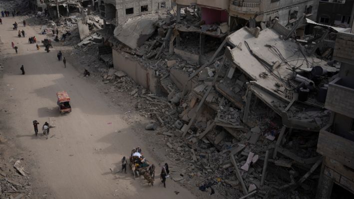 Personas caminan entre la destrucción luego de una ofensiva aérea y terrestre israelí en Khan Younis, sur de la Franja de Gaza, lunes 8 de abril de 2024. Israel dice que ha retirado sus últimas tropas terrestres de la ciudad, poniendo fin a una operación de cuatro meses. (AP Photo/Fatima Shbair)