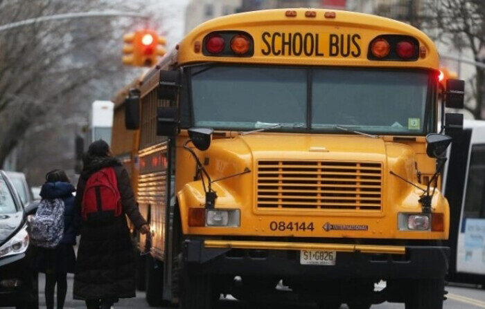 Estudiantes caminan para subir a un autobús escolar en Manhattan el 15 de enero de 2013. (Mario Tama/Getty Images)