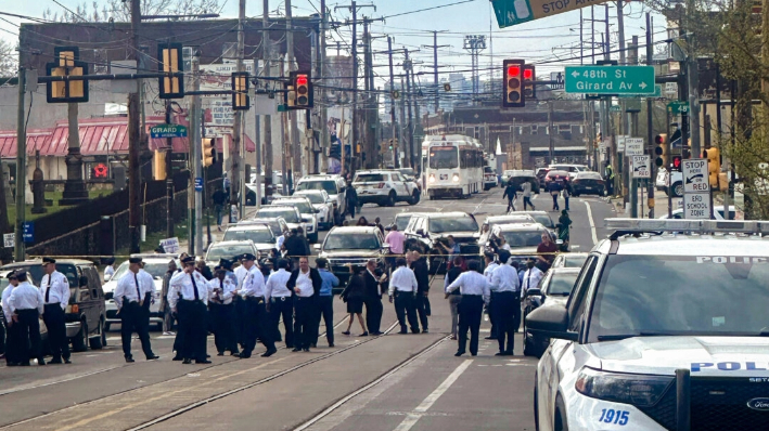 Policías y funcionarios se reúnen en una calle acordonada en la escena de un tiroteo en Filadelfia el 10 de abril de 2024. (Claudia Lauer/AP Photo)