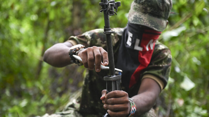 Un miembro del frente Ernesto Che Guevara, perteneciente a las guerrillas del Ejército de Liberación Nacional (ELN), limpia su arma en la selva del Chocó, Colombia, el 25 de mayo de 2019. (Raul Arboleda/AFP vía Getty Images)





