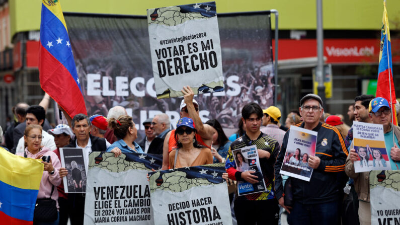 Manifestantes sostienen pancartas y carteles en los que se lee "Votar es mi derecho" durante una concentración para "exigir el fin de las violaciones de los derechos políticos y la defensa de los derechos humanos en Venezuela" en Madrid (España) el 6 de abril de 2024. (Oscar Del Pozo/AFP vía Getty Images)