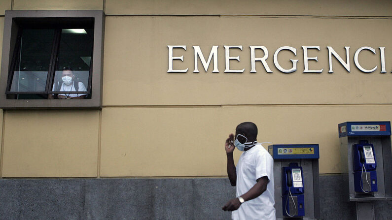 Un trabajador del Hospital Rafael Ángel Calderón Guardia, en San José, camina frente a esta institución con una mascarilla quirúrgica el 28 de abril de 2009. (Mayela Lopez/AFP vía Getty Images)