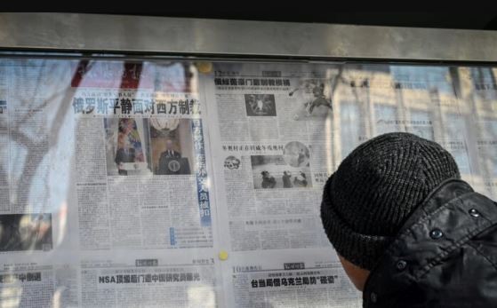 Un hombre lee el periódico estatal chino con cobertura del conflicto entre Rusia y Ucrania, en una calle de Beijing el 24 de febrero de 2022. (Jade Gao/AFP vía Getty Images)