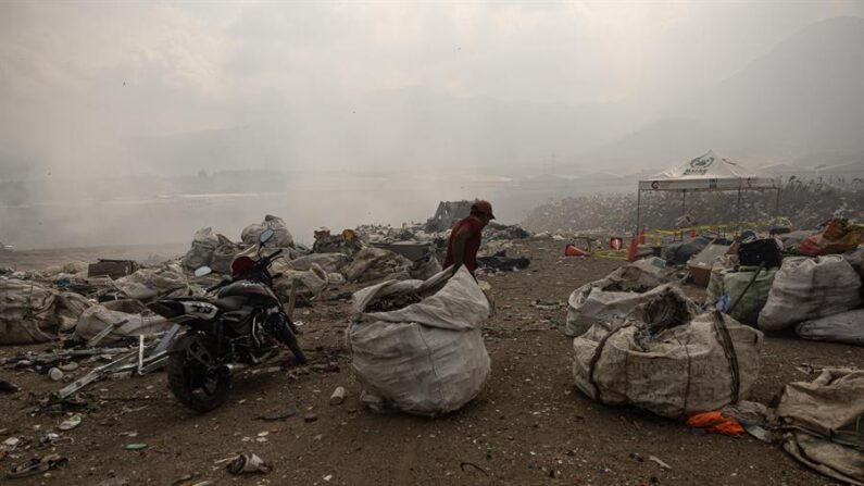 Un hombre arrastra una bolsa con material reciclable este 10 de abril de 2024 en un vertedero afectado por incendios forestales al sur de Ciudad de Guatemala (Guatemala). EFE/ David Toro
