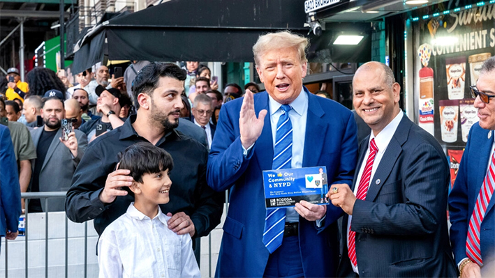 El expresidente Donald Trump junto a políticos locales y trabajadores de una bodega durante su visita a una bodega en el Alto Manhattan en Nueva York el 16 de abril de 2024. (Spencer Platt/Getty Images)
