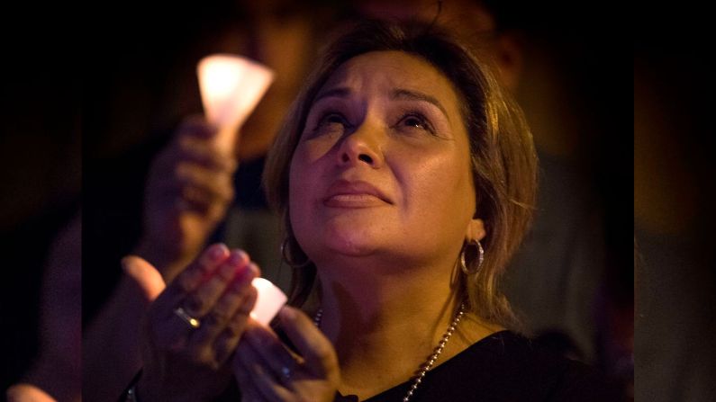 A woman prays during a candlelight vigil at the Immanuel Church en El Paso, Texas, (MARK RALSTON/AFP via Getty Images)
