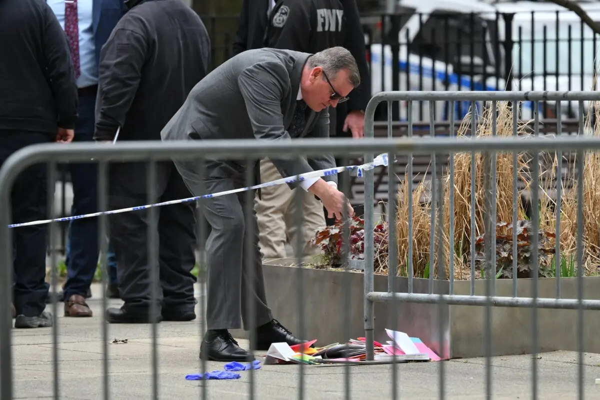 Un investigador toma fotografías de los panfletos arrojados por Max Azzarello después de prenderse fuego en el parque situado frente a la Corte Criminal de Manhattan, en Nueva York, el 19 de abril de 2024. (Angela Weiss/AFP/Getty Images)