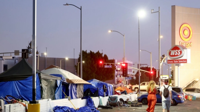 Un grupo de personas pasa por delante de un campamento de personas sin hogar cerca de una tienda Target en Los Ángeles el 28 de septiembre de 2023. (Mario Tama/Getty Images)

