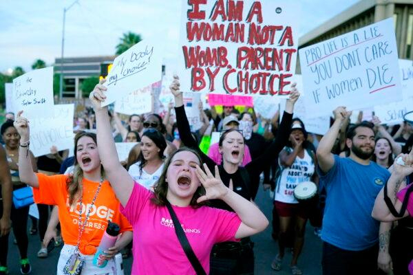 Manifestantes gritan mientras se unen a miles de personas que marchan alrededor del Capitolio de Arizona, en Phoenix, tras la decisión de la Corte Suprema de anular la histórica decisión sobre el aborto Roe vs. Wade, el 24 de junio de 2022. (AP Photo/Ross D. Franklin)