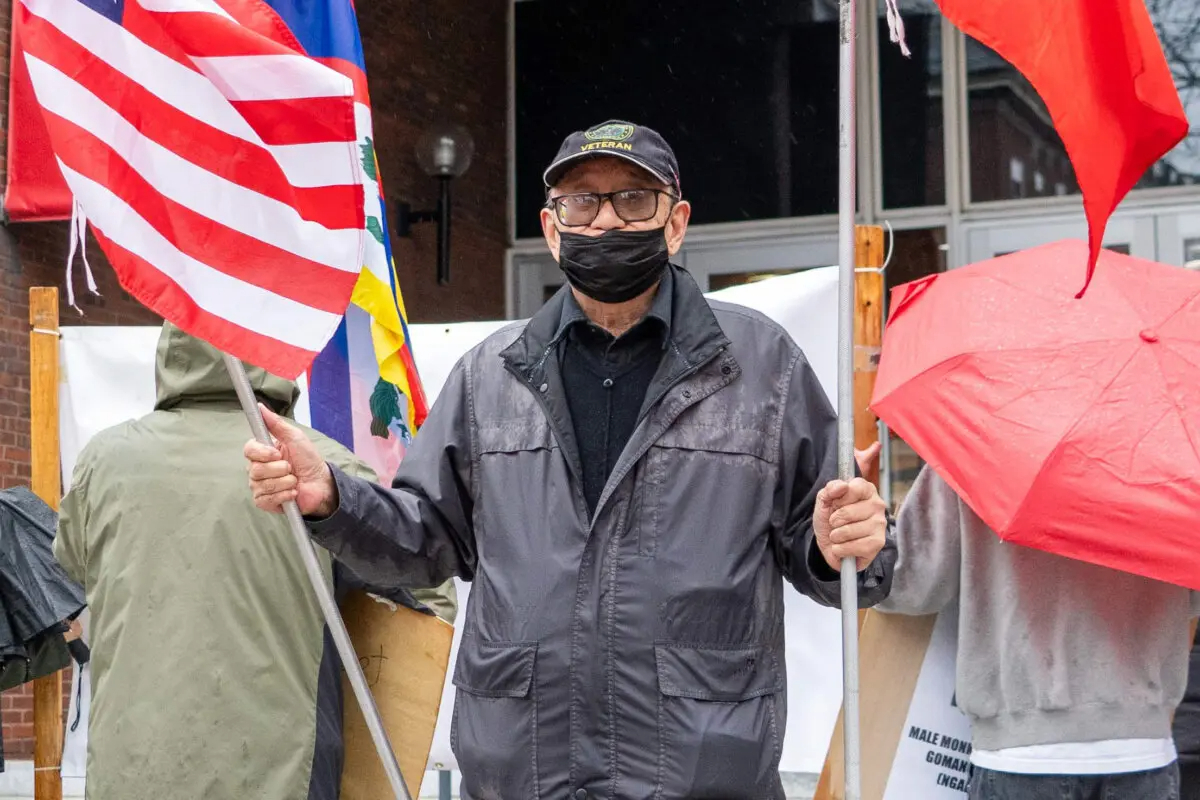 Che Chungchi, un manifestante, sostiene banderas de Estados Unidos y Taiwán en la Harvard Kennedy School de Cambridge, Massachusetts, el 20 de abril de 2024. (Learner Liu/The Epoch Times)