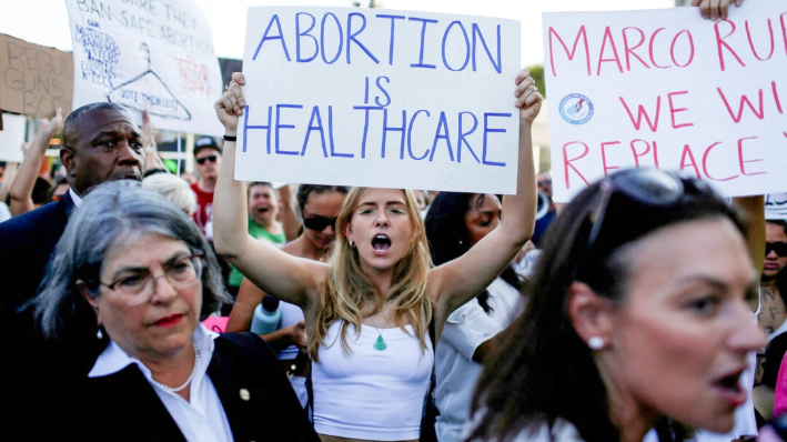 Una manifestante sostiene un cartel mientras se manifiesta en Miami después de que el Tribunal Supremo de EE.UU. fallara en el caso del aborto Dobbs v. Jackson Women's Health Organization, anulando la histórica decisión sobre el aborto Roe v. Wade, el 24 de junio de 2022. (Marco Bello/Reuters)