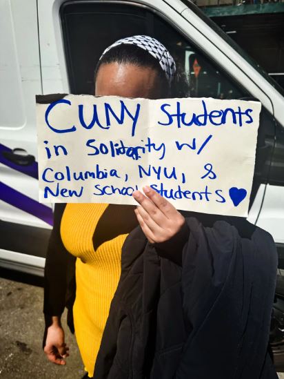 Una estudiante de CUNY no identificada sostiene un cartel en apoyo de la manifestación propalestina del 22 de abril de 2024. (Juliette Fairley/The Epoch Times)