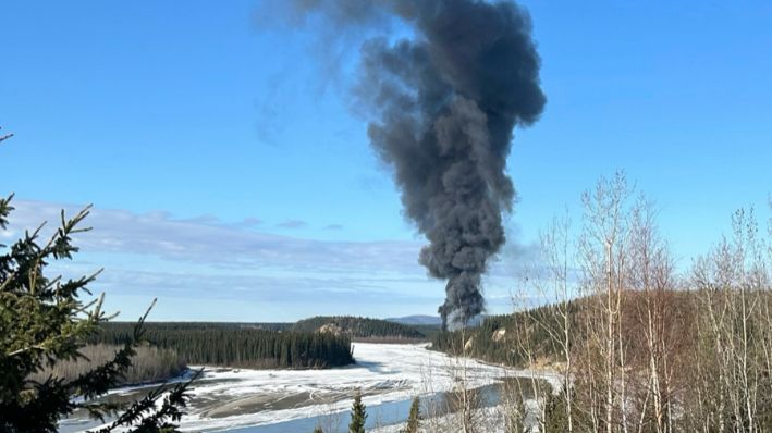Se levanta humo después de que un avión Douglas C-54 Skymaster se estrellara en el río Tanana a las afueras de Fairbanks, Alaska, el martes 23 de abril de 2024. (Gary Contento vía AP)