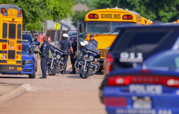 Agentes de policía se preparan para escoltar a los estudiantes a reunirse con sus familias en Arlington Bowie High School después de que la escuela fue puesta en un cierre debido a un presunto tiroteo fuera del edificio de la escuela en Arlington, Texas, el 24 de abril de 2024. (Gareth Patterson/Foto AP)