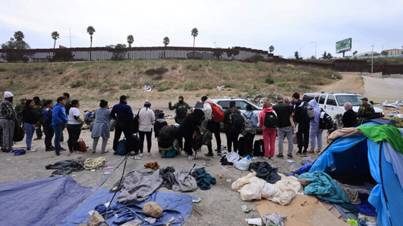 Agentes de la Patrulla Fronteriza procesan a inmigrantes ilegales entre las vallas primaria y secundaria de la frontera entre México y Estados Unidos en San Diego, California, el 22 de septiembre de 2023. (David Swanson/AFP vía Getty Images)