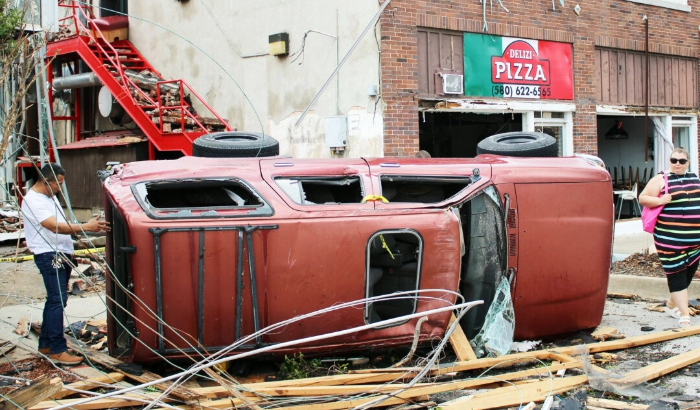 El propietario de una pizzería, César Trinidad, inspecciona su camión dañado afuera de su restaurante en Sulphur, Oklahoma, el 28 de abril de 2024. (Michael Clements/The Epoch Times)
