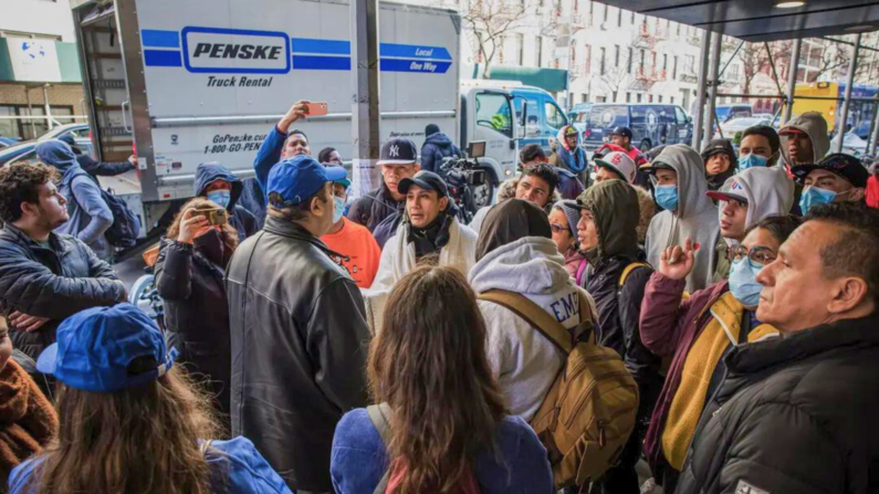 Un miembro de la oficina de inmigración del alcalde de la ciudad de Nueva York habla con inmigrantes ilegales que acampan frente al Hotel Watson después de ser desalojados, en la ciudad de Nueva York el 30 de enero de 2023. (Michael M. Santiago/Getty Images)