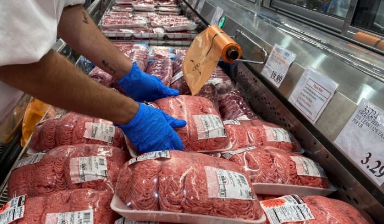 Un trabajador apila paquetes de carne molida en la sección de carnes de una tienda en Webster, Texas, el 5 de mayo de 2020. (Adrees Latif/Reuters)