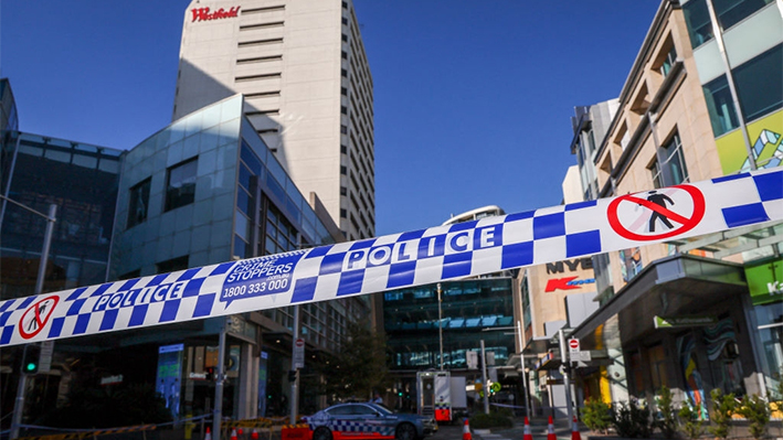 Se puede ver cinta policial delante de un control de carretera fuera del centro comercial Westfield Bondi Junction en Sídney, Australia, el 14 de abril de 2024. (David Gray/AFP vía Getty Images)
