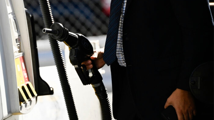 Un cliente devuelve al surtidor una boquilla después de recargar gasolina en un vehículo deportivo utilitario (SUV) en una gasolinera Shell del barrio de Chinatown de Los Ángeles, California, el 17 de febrero de 2022. (Patrick T. Fallon/AFP vía Getty Images)
