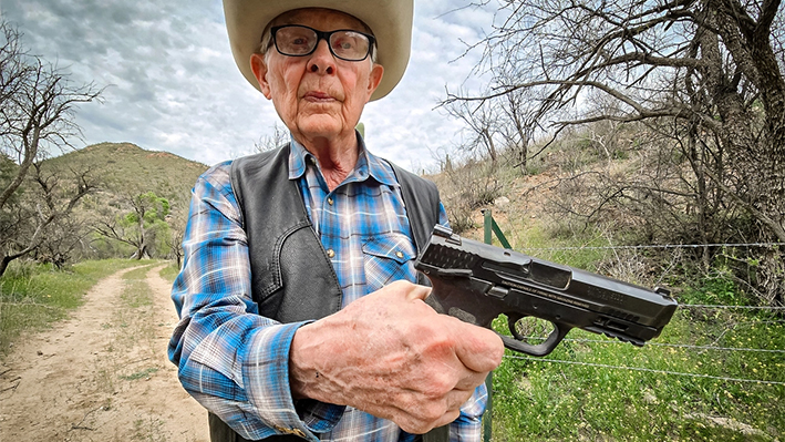 El ganadero Jim Chilton muestra la pistola de calibre 40 que lleva cuando sale a su rancho de 50,000 acres en Arivaca, Arizona, el 22 de marzo de 2024. (Allan Stein/The Epoch Times)
